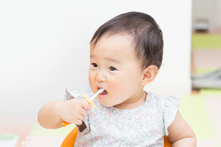 ハブラシを持つ赤ちゃん
